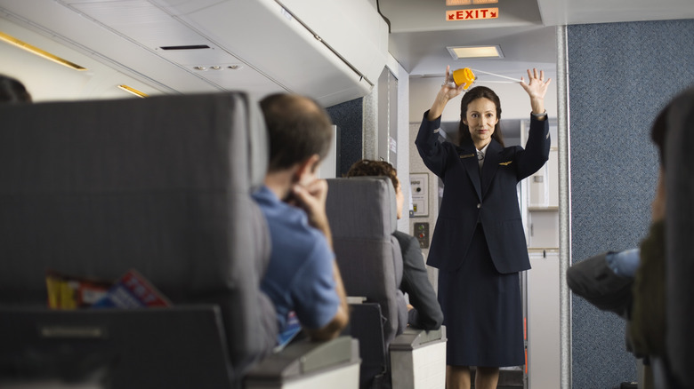 Flight attendant giving instructions