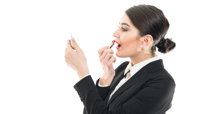 Flight attendant putting on makeup