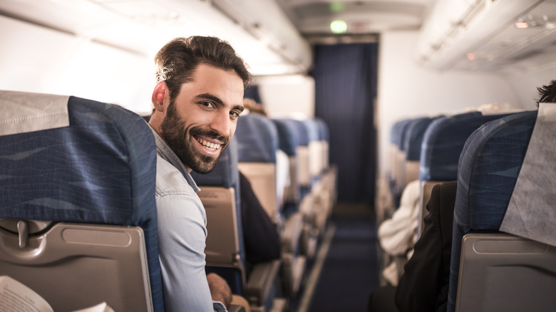 doofus smiling on a plane