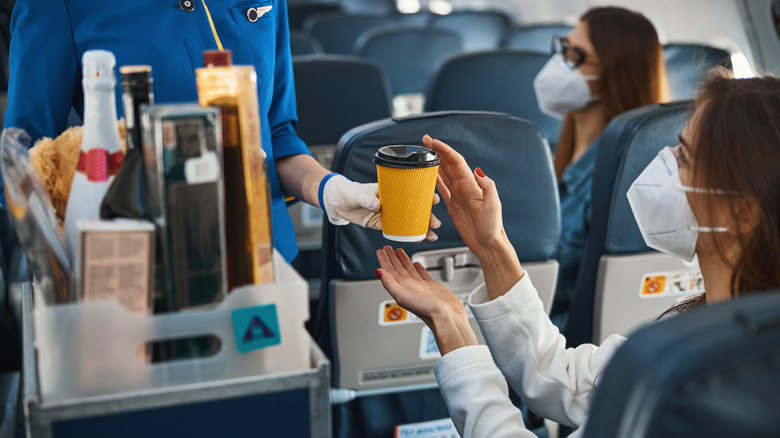 Flight attendant giving coffee