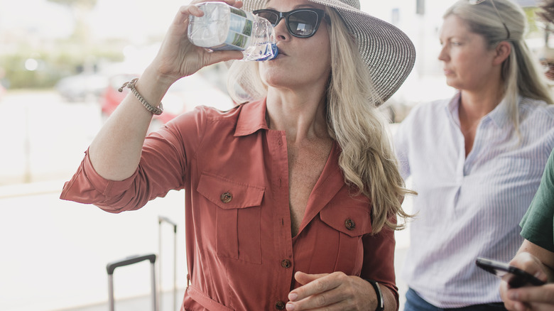 woman drinking water before flight