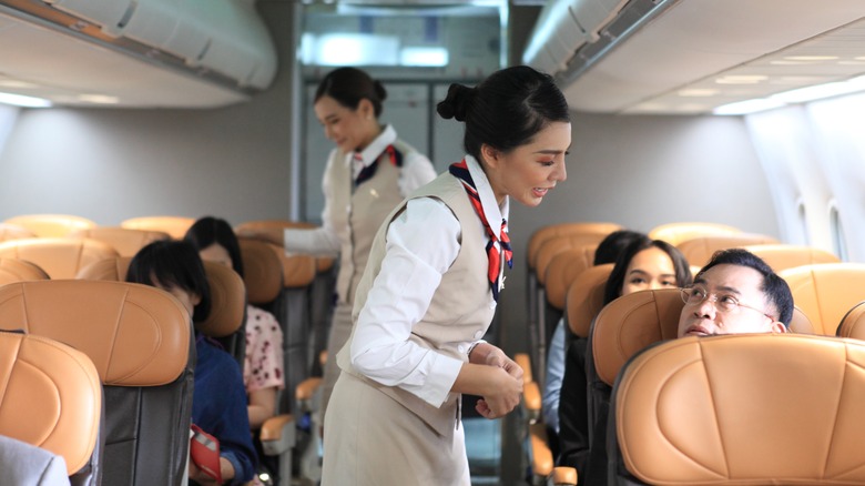 Flight attendant speaking to passenger