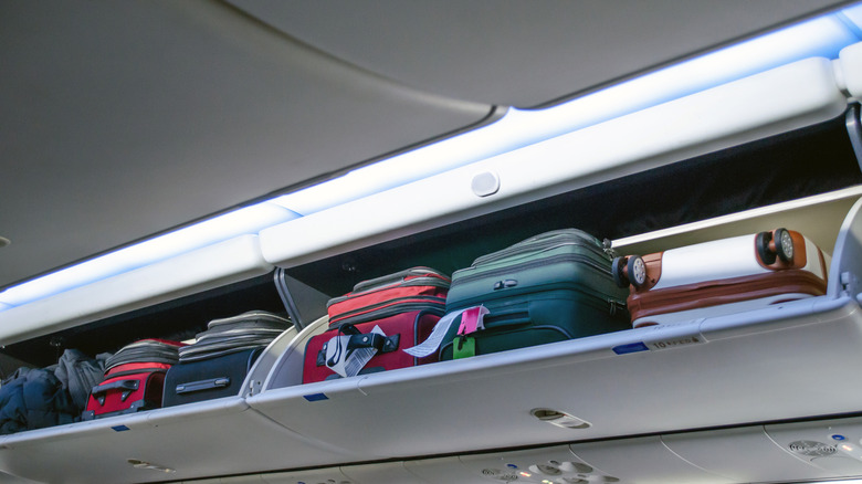 luggage in airplane overhead bin compartment