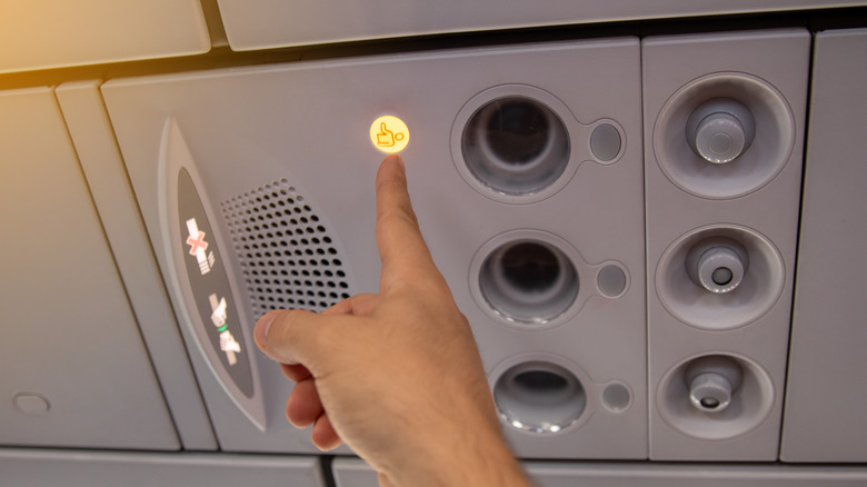hand pushing airplane call button