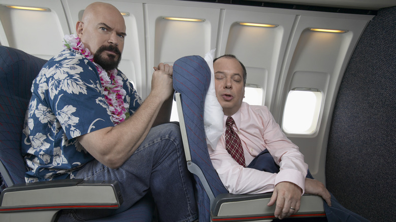 annoyed passenger seat back airplane