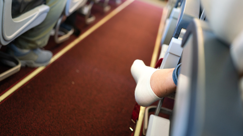white sock shoeless airplane aisle