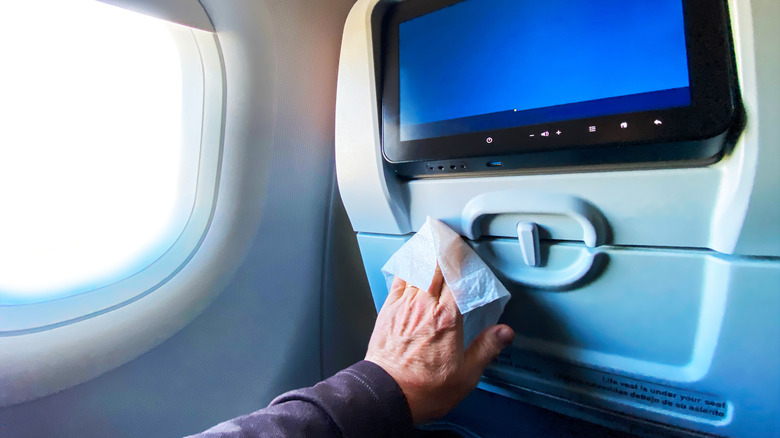 Passenger wiping down airplane seat