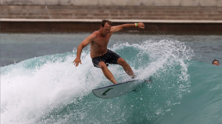 Man surfs in wave pool