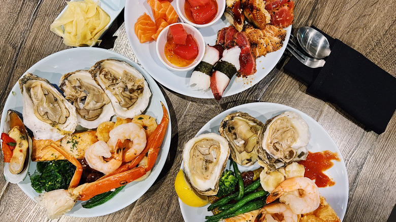 three plates of various seafood at a restaurant