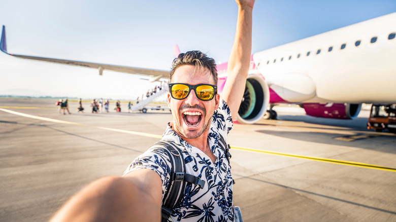 Man takes selfie in front of grounded airplane