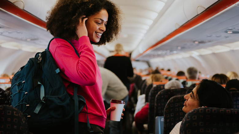 Conversing woman wears backpack on airplane