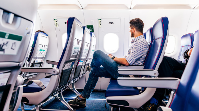 Man occupies a seat on an airplane