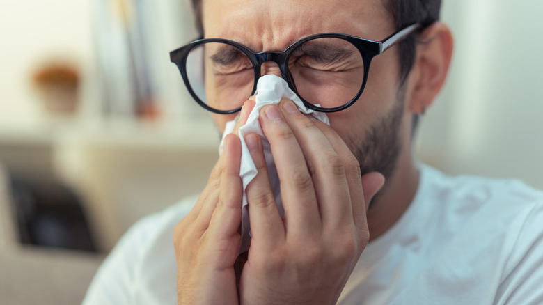 A traveler blowing their nose