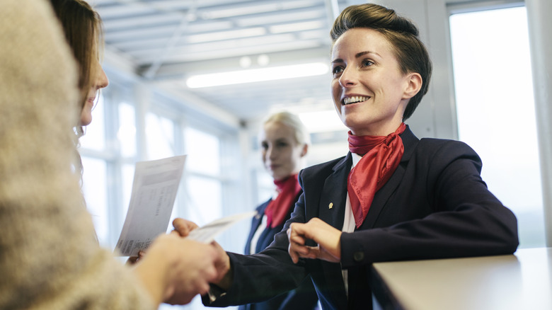 A smiling flight attendant welcoming passengers