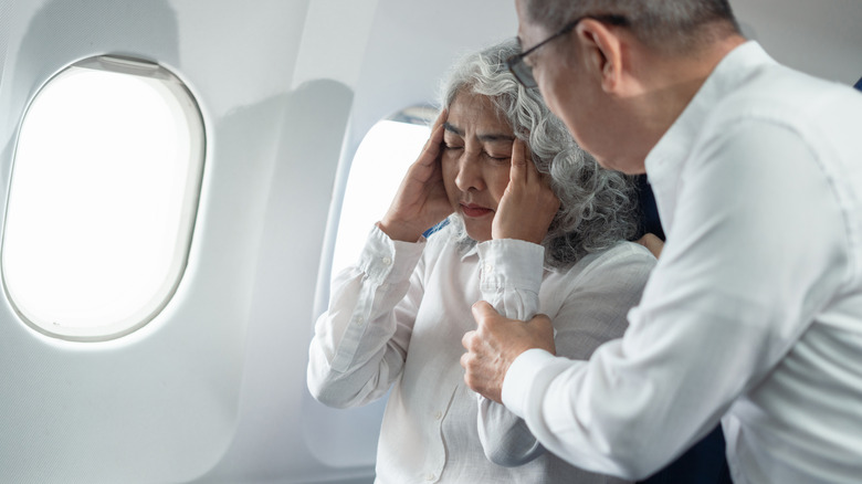 An airplane passenger looking visibly ill