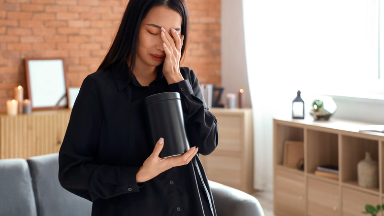 Grieving woman carrying urn