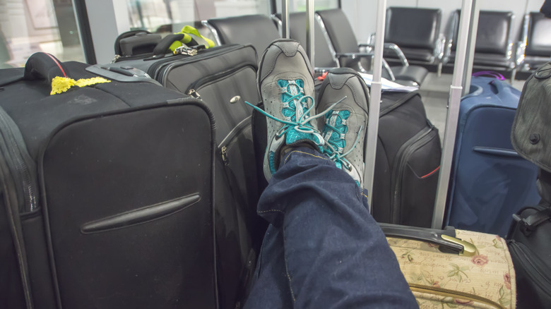 person resting feet on luggage