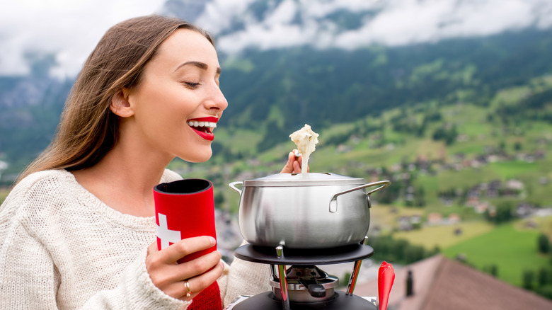 Woman eating fondue in the Alps