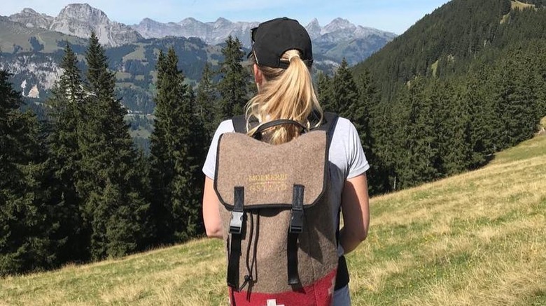 Woman with a fondue backpack in Switzerland