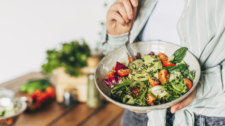 Person holding a bowl of healthy salad.