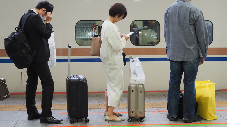 Passengers wait for a train in Japan