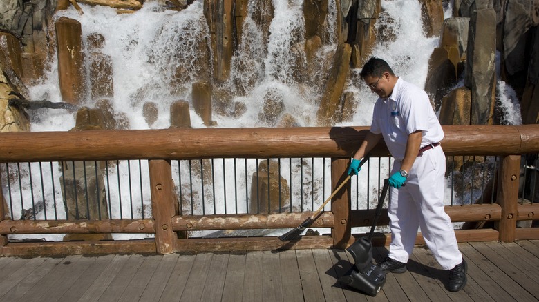 Employee cleaning up trash at theme park