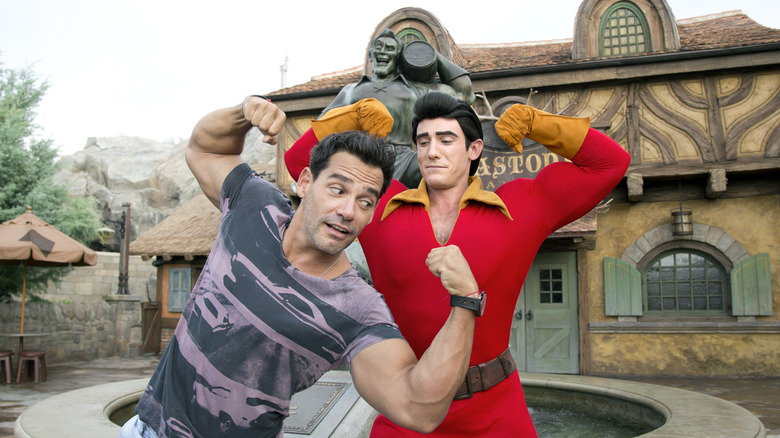 Actor flexing with Gaston from "Beauty and the Beast"