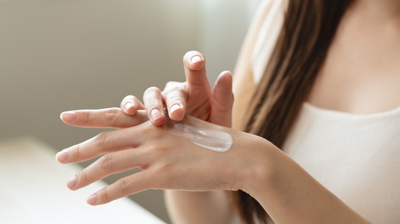 woman with moisturizing cream on hand