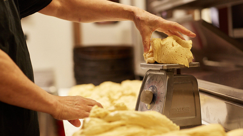 Person weighing dough