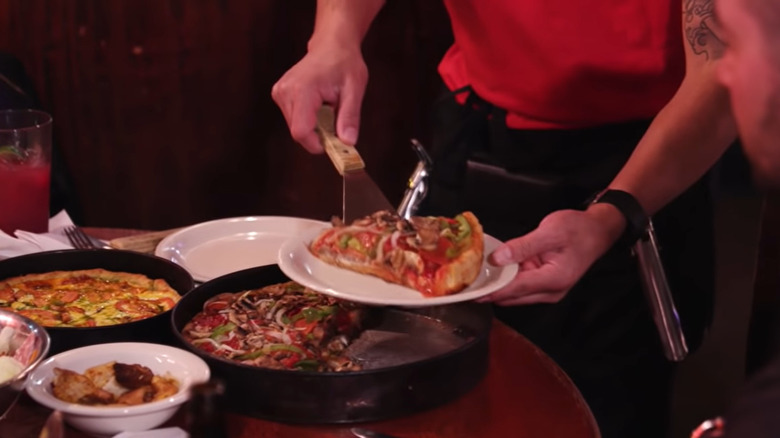 Photo of people toasting over pizzas