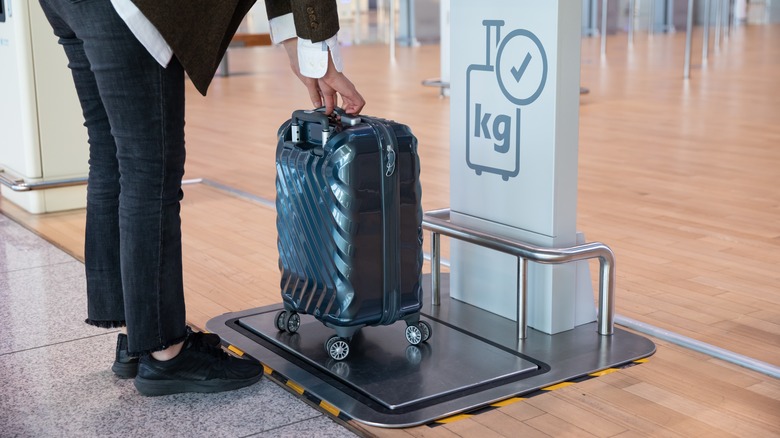 person weighing luggage