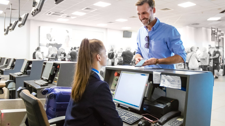 Traveler standing at a check-in counter.