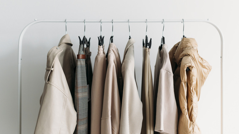 neutral-colored clothes hanging on rack 