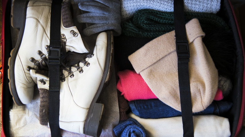 winter clothes and shoes in suitcase