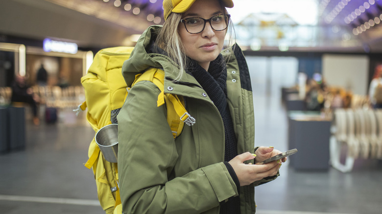 bespectacled woman wearing coat at airport