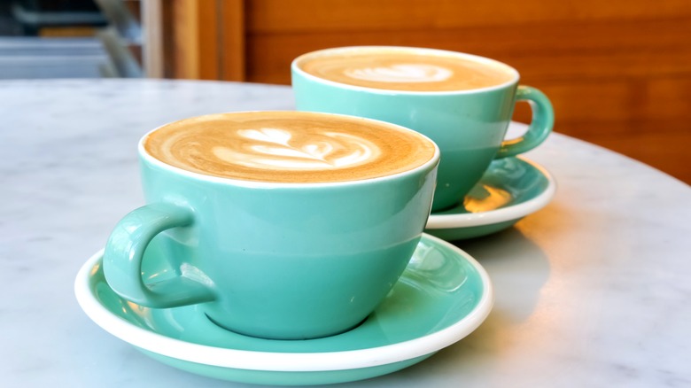 two cups of specialty coffee in mint green mugs