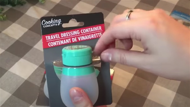 Hands holding travel dressing container