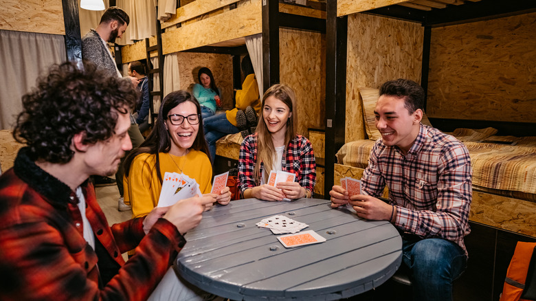 Young people playing cards in hostel