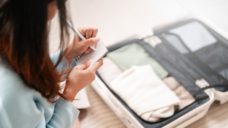 woman packing clothes in suitcase