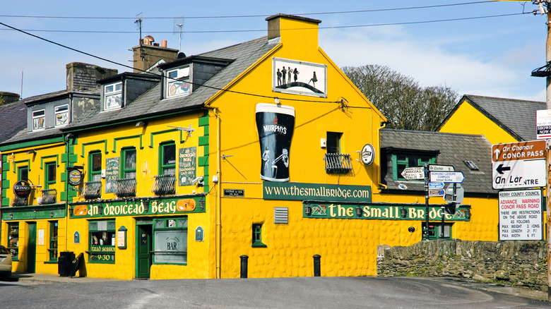 Yellow pub with Guinness mural on wall