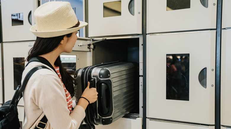 woman storing luggage in locker