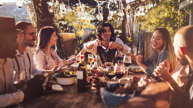 smiling friends eating outdoors