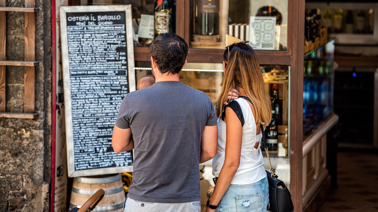 tourists reading Italian restaurant menu