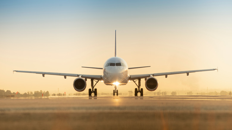 airplane on runway at sunset