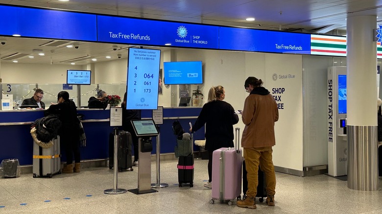 Travelers in line at refund kiosk