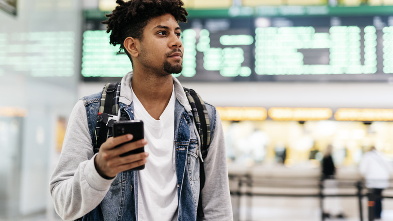 Traveler using cellphone at the airport