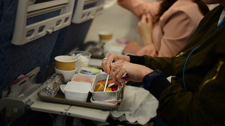 Person eating food on plane