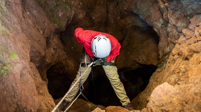 Climber descending into a cave
