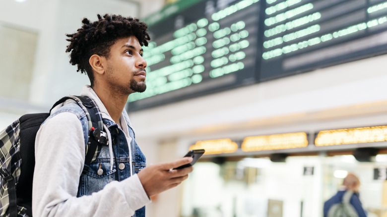 man looking at departure board