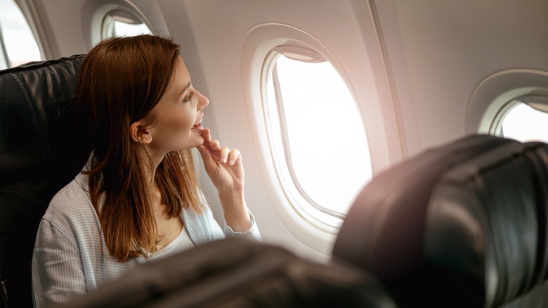 Woman looking out airplane window